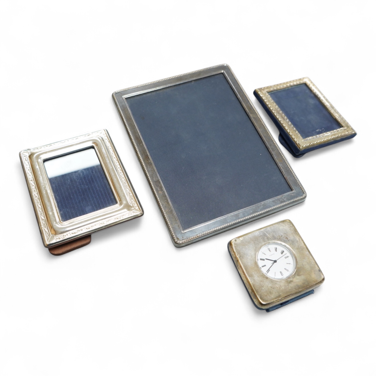 Two modern silver mounted photograph frames, largest 20.4cm by 15.2cm, an Italian 925 mounted photograph frame and a modern silver mounted desk timepiece.
